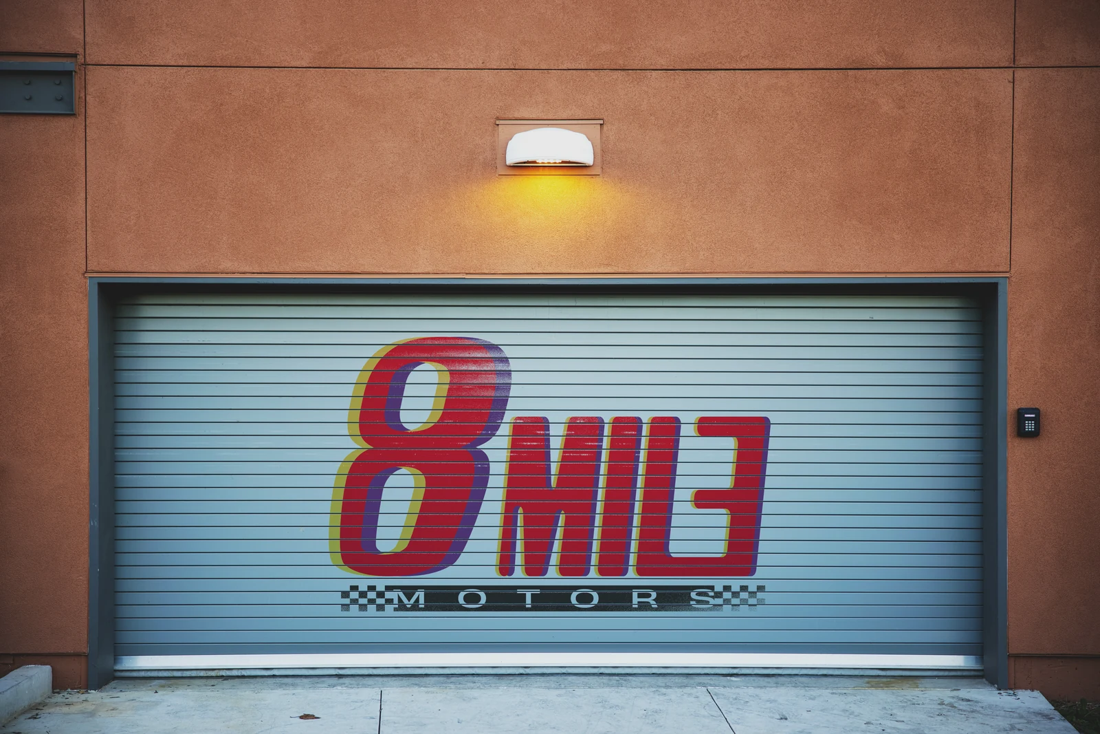 8 Mile Motors logo displayed across a garage shutter in an exterior mockup.