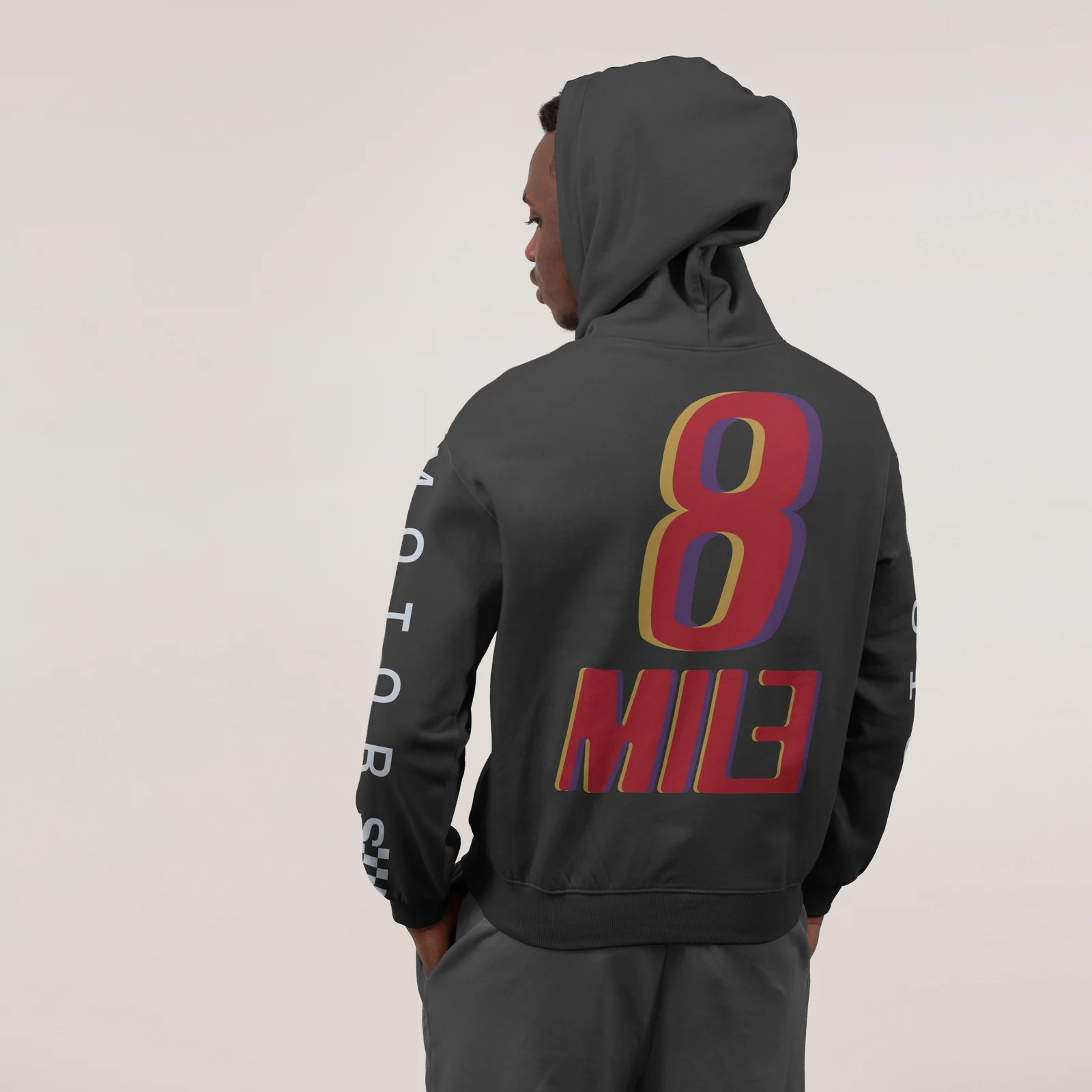 Dark hoodie mockup carrying the full-colour 8 Mile Motors logo on the back.